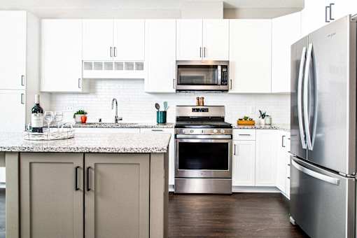 Modern kitchen with sleek stainless steel appliances, granite countertops, a built-in dishwasher, and a stylish gas range. Minnetonka, MN.
