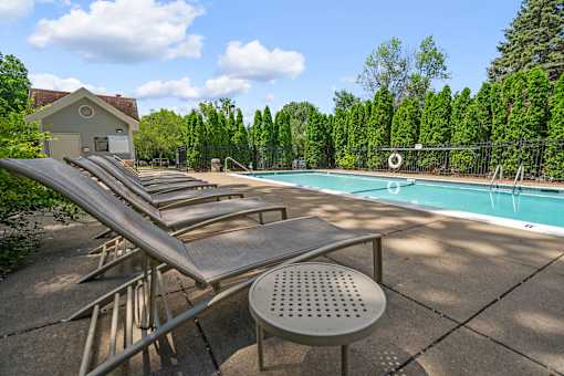 a group of chaise lounge chairs next to a pool