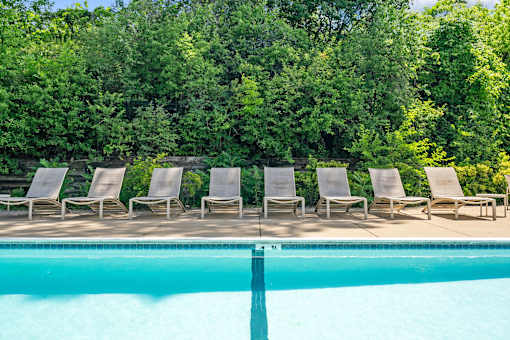 a group of lounge chairs next to a swimming pool