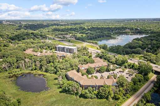 an aerial view of a campus with a lake and buildings