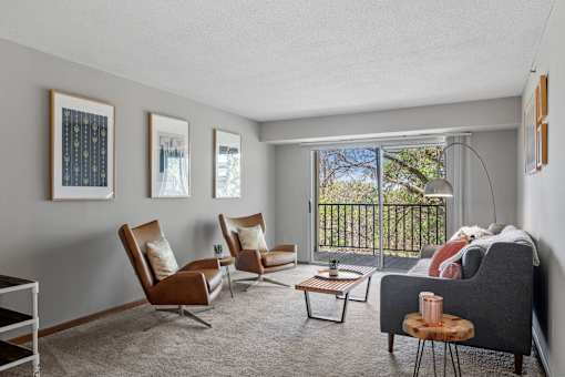 a living room with a couch and chairs and a window