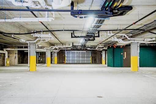 Underground parking lot at the modern apartment complex, featuring state-of-the-art electric vehicle chargers. A well-lit and spacious area with designated charging stations, ensuring convenience for residents with electric cars.