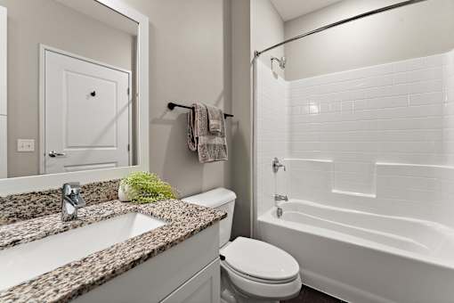 A white toilet sits next to a sink in a bathroom.