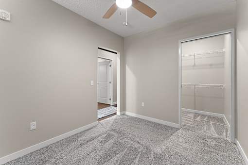 A room with a ceiling fan and a carpeted floor.