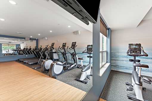 A gym with treadmills and elliptical machines.