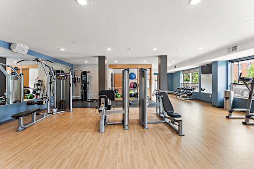 A gym with a variety of equipment including weights and cardio machines.