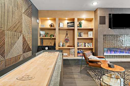 A modern living room with a fireplace and a shelving unit.
