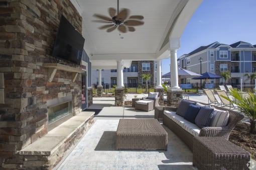 a patio with a fireplace and wicker furniture at The Retreat at Sumter, Sumter, South Carolina