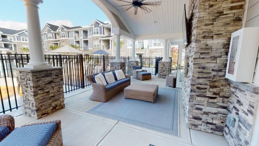 a patio with couches and chairs and a fireplace at The Retreat at Fuquay-Varina Apartments, Fuquay-Varina