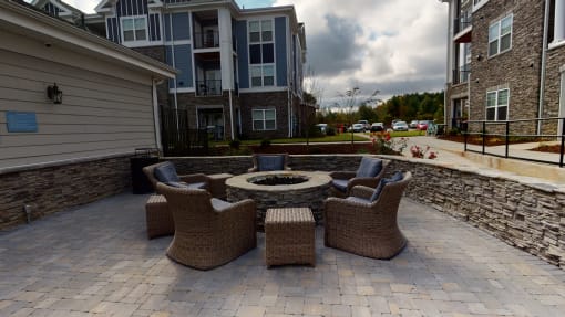 a patio with a fire pit and wicker furniture at The Retreat at Fuquay-Varina Apartments, Fuquay-Varina