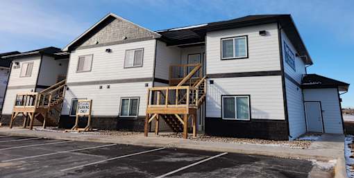 A row of houses with a sign that says "For Sale".