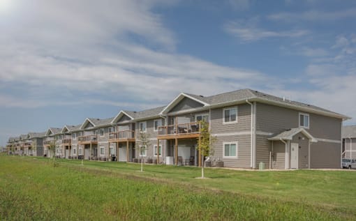 A row of houses with a grassy field in front.