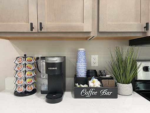 A coffee bar with a Keurig machine and a decorative container.