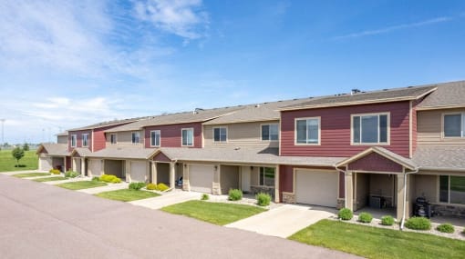 a row of townhomes on a street with grass