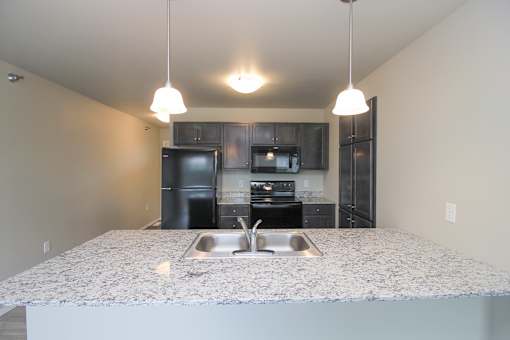 A kitchen with granite countertops and stainless steel appliances.