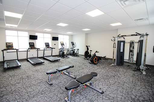 A gym with a variety of equipment including treadmills, exercise bikes, and weight machines.