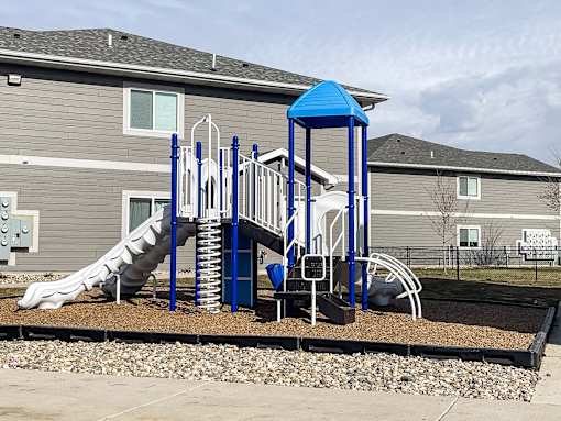 A playground with a blue structure and a slide.
