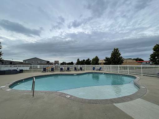 A large outdoor swimming pool with a metal fence around it.