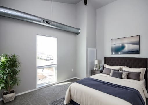A bedroom with a large bed and a painting on the wall.