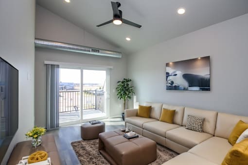 A living room with a white couch and a brown ottoman.