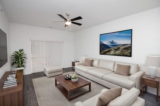 A living room with a large painting of a mountain landscape on the wall.