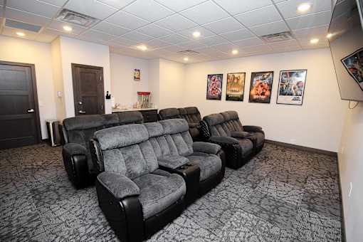 A row of black recliner chairs are lined up in a room.