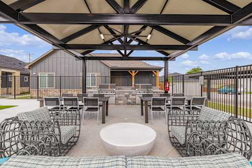 A patio with a table and chairs under a canopy.