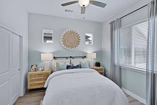 A bedroom with a bed, nightstands, and a ceiling fan.