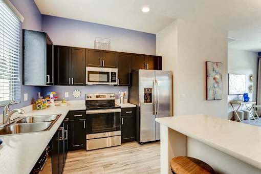 A kitchen with black cabinets and stainless steel appliances.
