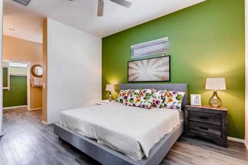 A bedroom with a bed, nightstand, and lamp.