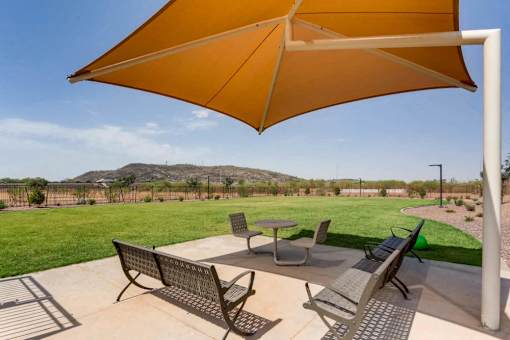 A patio with a table and chairs under a large umbrella.