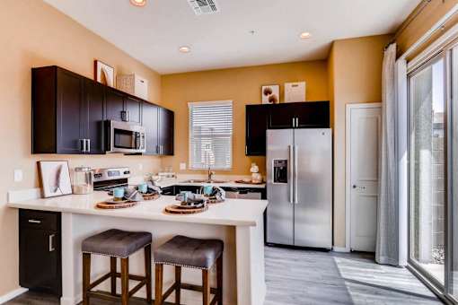 A kitchen with a white countertop and a black refrigerator.