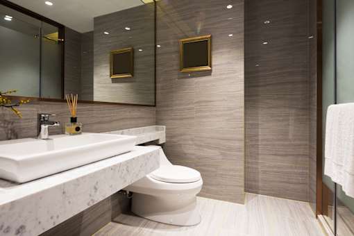 A bathroom with a marble countertop and a toilet.
