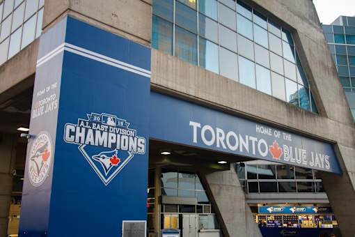 A blue and white sign for the Toronto Blue Jays is displayed on a building.