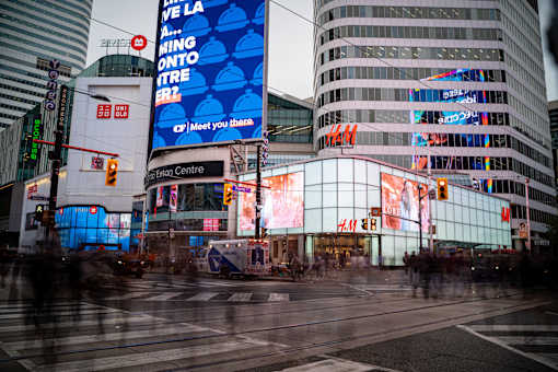 A busy city intersection with a large billboard that says "Meet you there".