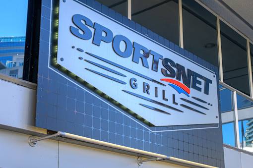 A sign for Sportsmnet Grill is displayed on a building.
