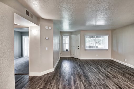 an empty living room with hardwood floors