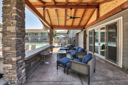 a covered patio with furniture and a pool in the background
