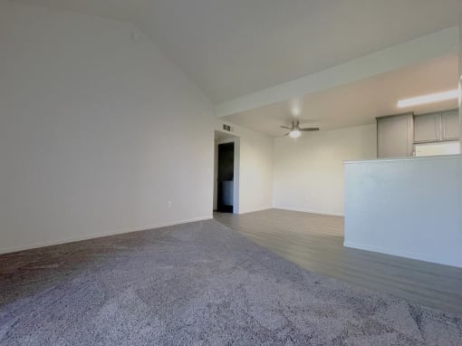an empty living room with white walls and a concrete floor at Sharlands Terrace Apartments, Reno, NV, 89523