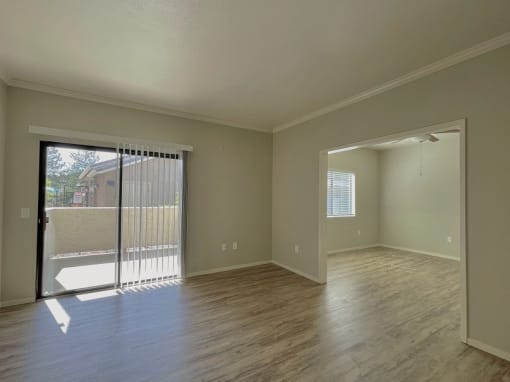 an empty living room with a sliding glass door to a balcony at Sharlands Terrace Apartments, Reno, 89523