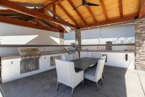 a large outdoor kitchen with stainless steel appliances and a wooden ceiling