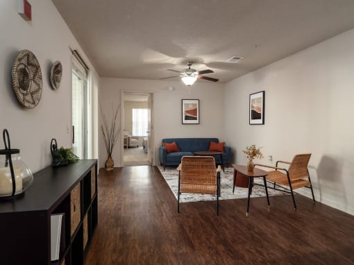 a living room with a couch and a table and a ceiling fan at The Fountains Apartments, Pensacola, Florida