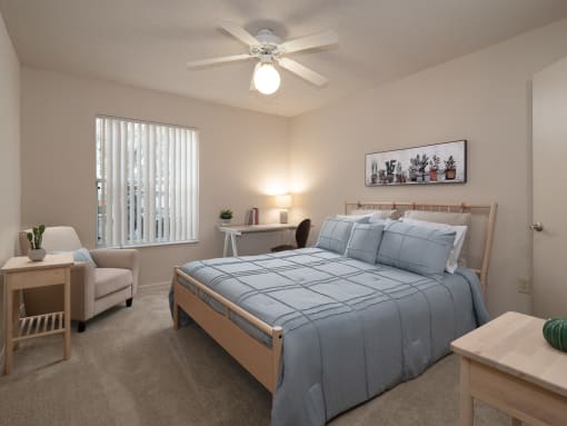 a bedroom with a large bed and a ceiling fan at The Fountains Apartments, Pensacola, FL