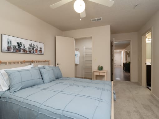 a bedroom with a bed and a closet and a ceiling fan at The Fountains Apartments, Pensacola, FL