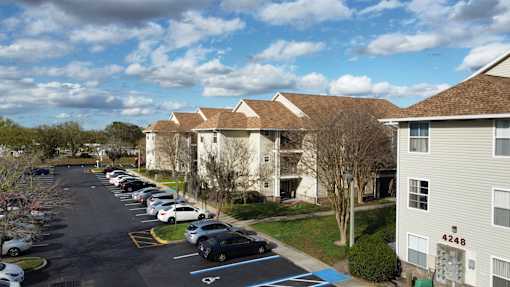a row of houses with cars parked in a parking lot at Tivoli Apartments of Orlando, Oviedo, FL