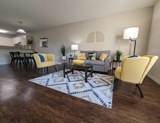 a living room with yellow chairs and a rug at Tivoli Apartments of Orlando, Oviedo, Florida, 32765