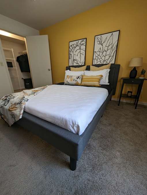 a bedroom with a bed and two paintings on the wall at Tivoli Apartments of Orlando, Oviedo, FL