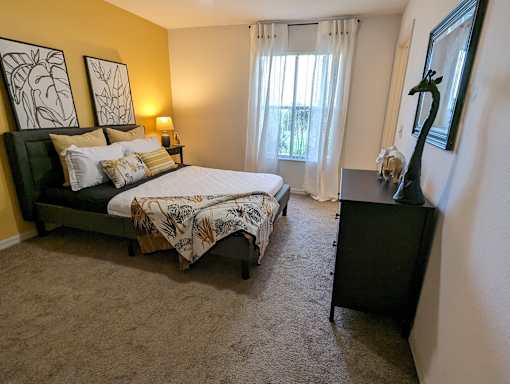 a bedroom with a bed and a dresser and a window at Tivoli Apartments of Orlando, Oviedo, Florida