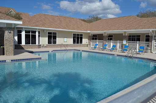 a large swimming pool in front of a building with a resort style pool at Tivoli Apartments of Orlando, Oviedo, Florida