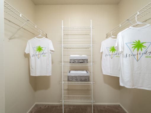a closet with white shirts and a rack with towels on it at Stoneridge Apartments, Gainesville, 32608